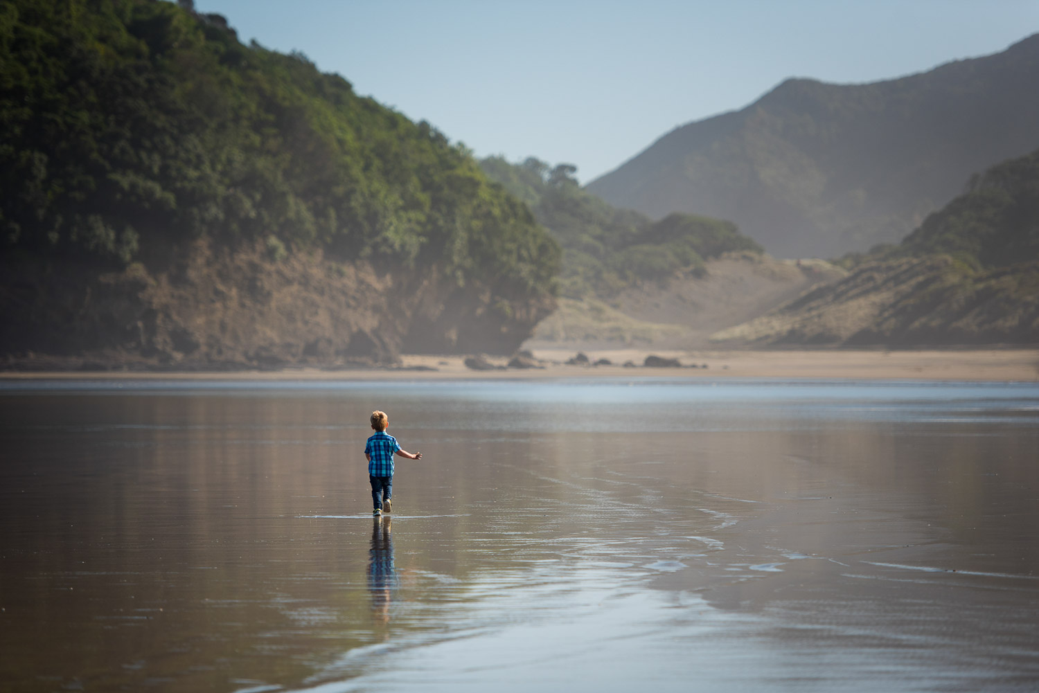 boy running at beach by auckland family photographer siobhan kelly photography