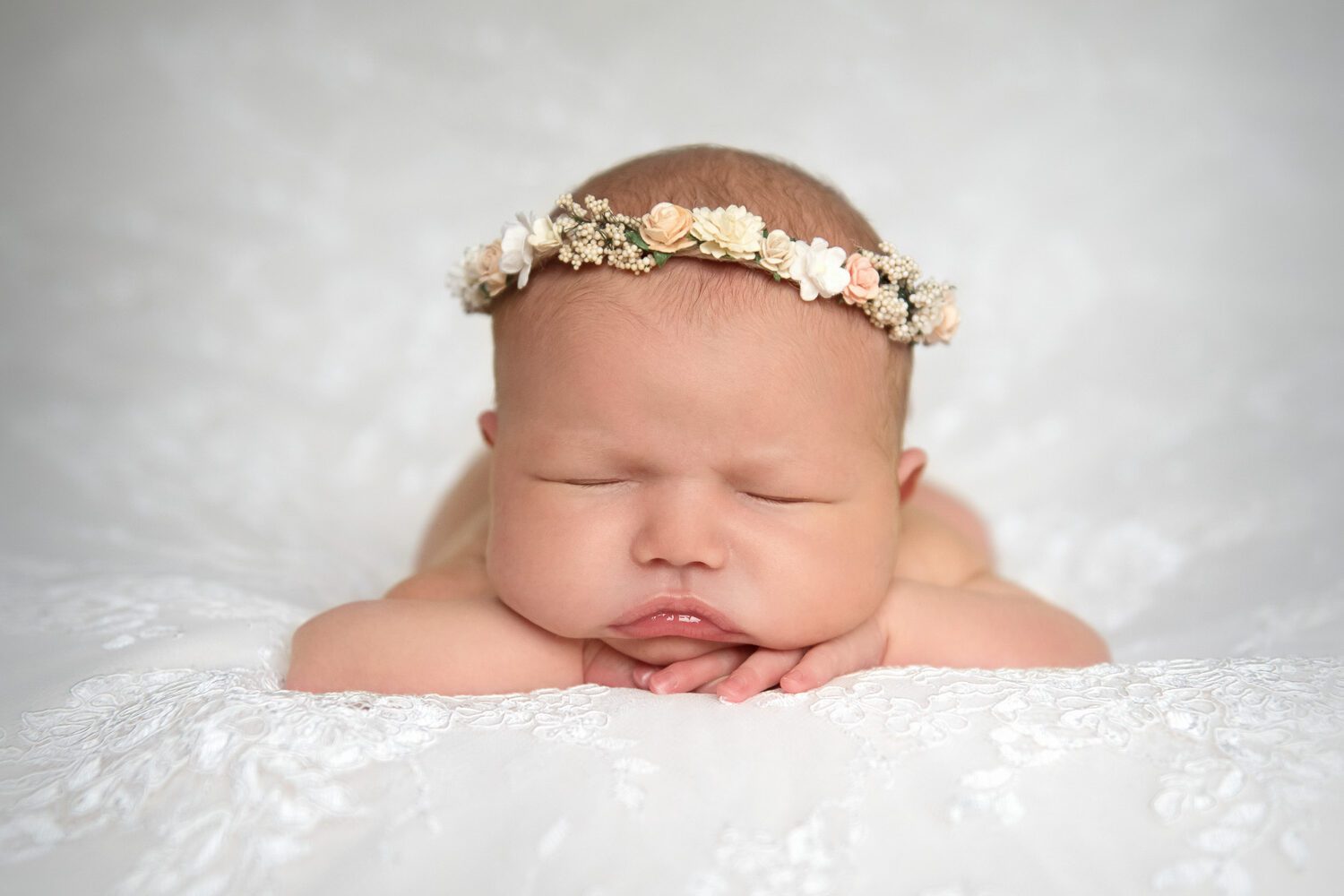 newborn baby on wedding dress fabric by newborn photographer siobhan kelly