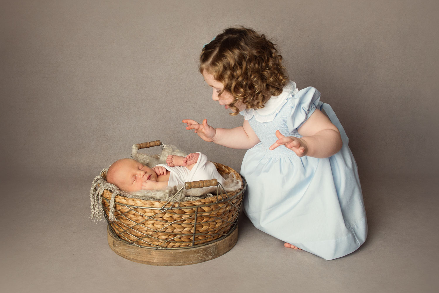 baby in basket with sister by siobhan kelly photography