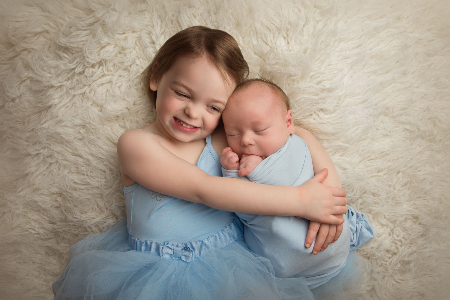 Photograph of newborn baby and sister by auckland newborn photographer siobhan kelly photography