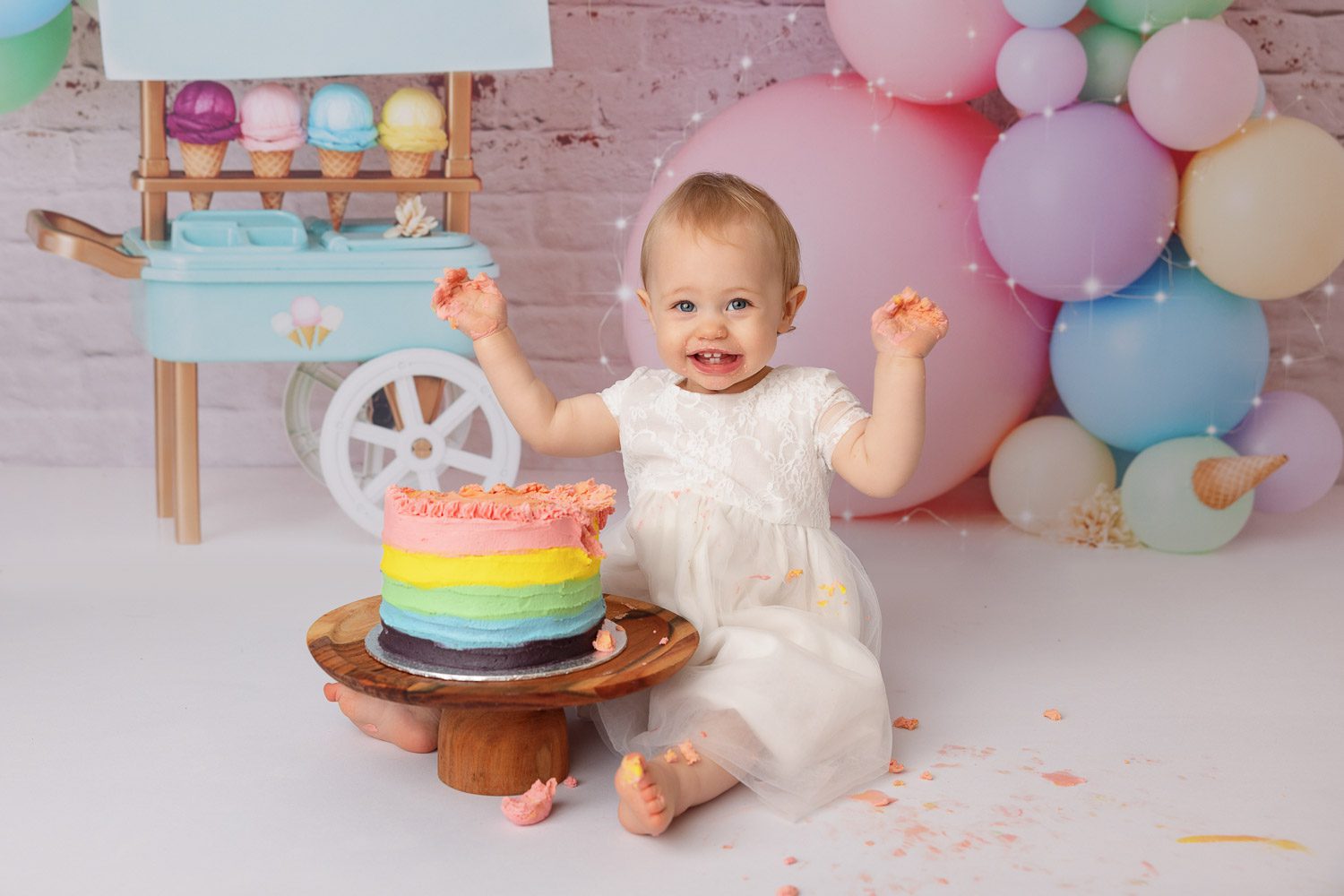 Auckland Cake Smash Photography 1 girl smashing rainbow cake for cake smash photography session by cake smash photographer siobhan kelly photography